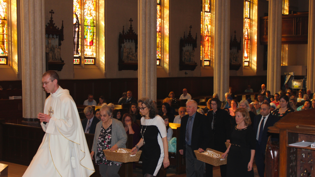 Laypeople carry oils for Chrism Mass blessing